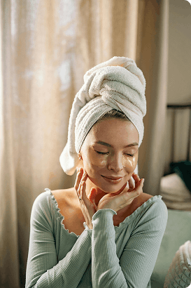 Entspannte Frau mit Handtuch und Augenpads